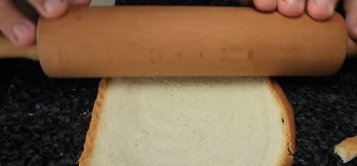 He Flattens Sandwich Bread to make strawberry french toast roll ups